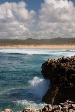 Bilinmeyen balıkçılar engebeli ve aşınmış yüksek kayalıklardan Atlas Okyanusu 'na bakan bir olta kamışlarıyla avlanırlar..