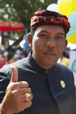 Şenlikli saç bandı takmış Asyalı bir adamın portresi.