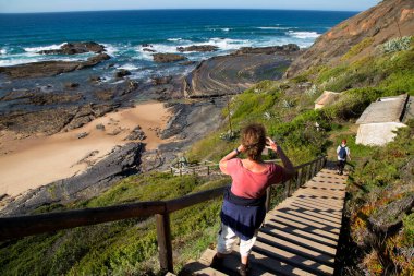 Merdivenlerden deniz kıyısına inen çift.