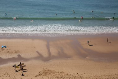 İnsanlar Atlantik Okyanusu kıyısında plajın tadını çıkarıyorlar.