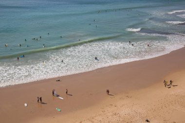 İnsanlar Atlantik Okyanusu kıyısında plajın tadını çıkarıyorlar.