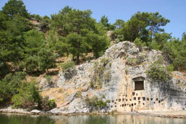 Denizde kayalar ve dağlarla terk edilmiş eski bir taş..