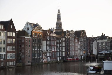 Amsterdam kanal kemerinde sokak hayatı ve mobilyalarla tipik Hollanda mimari binaları