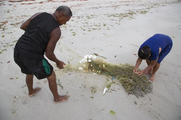 Sahilde ağlarla çalışan insanlar, seyahat çekimleri.