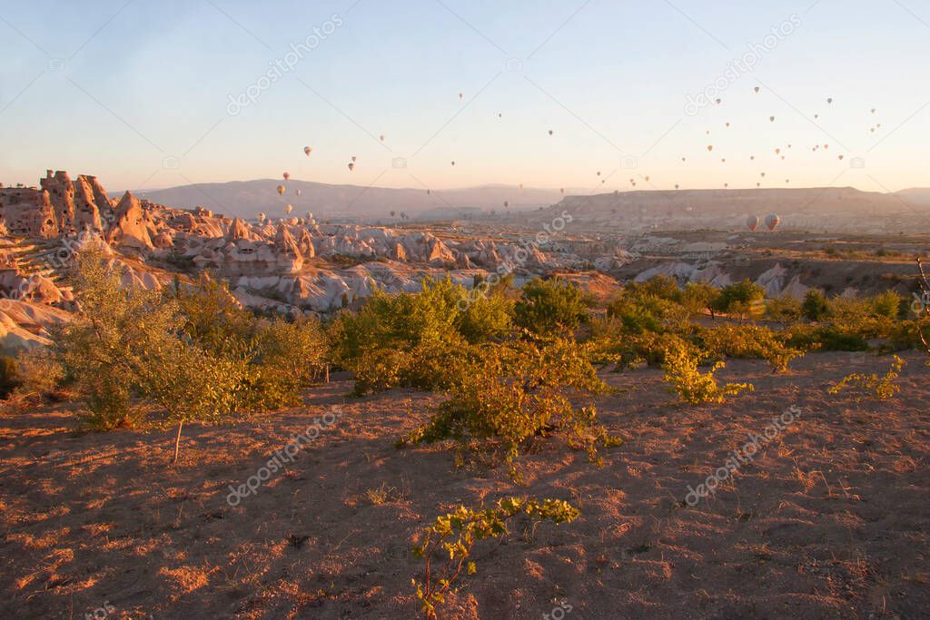 drifting hot air balloons with tourists who enjoy overwhelming views over a volcanic landscape above the national park
