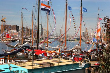 Güneşli limana demirlemiş bayraklı yatlar