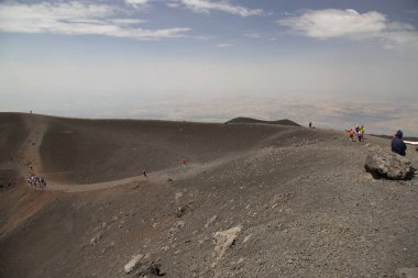 Bir grup turist güzel bir dağ manzarasında yürüyor.