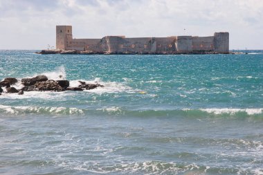 Mavi gökyüzü olan eski taş duvar.