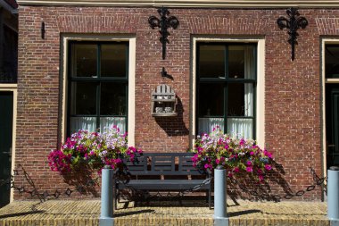 Banklar ve çiçeklerle eski bina cephesinin ön görüntüsü