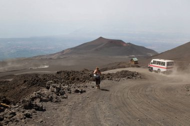 Sırt çantalı bir kadın yol ve dağ boyunca yürüyor, seyahat konsepti.
