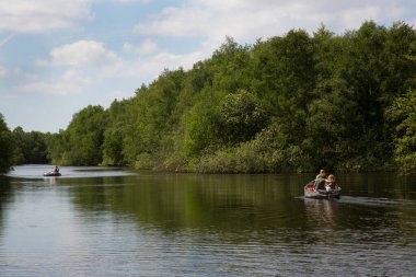 Parkta nehirde yüzen insanlar