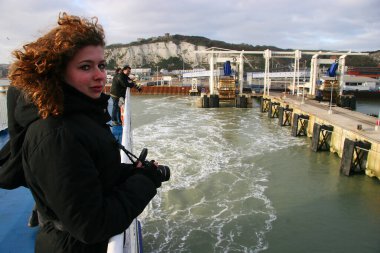 Bilinmeyen kadın turist fotoğrafçısı teknede poz veriyor ve fotoğraf çekiyor.