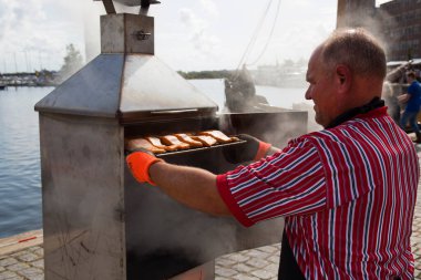 Barajda balık pişiren bir adamın görüntüsü.