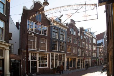 Amsterdam kanal kemerinde sokak hayatı ve mobilyalarla tipik Hollanda mimari binaları