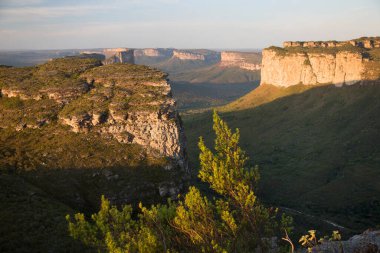 Güneşin yemyeşil olduğu kayalık manzaralı güzel bir manzara.