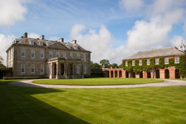 Kırsaldaki tipik bir İngiliz kır evi. Geniş çimleri ve süslemeleri olan geniş bir bahçesi var.