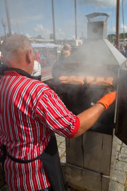 Barajda balık pişiren bir adamın görüntüsü.