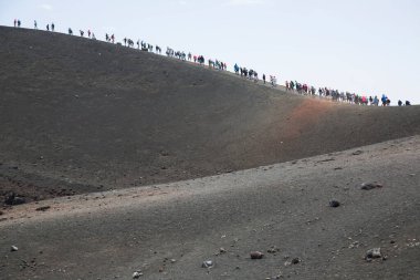 Bir grup turist güzel bir dağ manzarasında yürüyor.