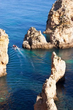 Tipik ve turistik engebeli ve çökmekte olan dengesiz Algarve kayalık kıyıları denizlerde kayalık tepeler, mağaralar, kemerler ve gizli cennet kumsalları