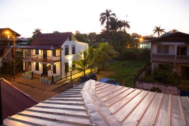 Palmiye ağaçları ve günbatımı olan ahşap ev