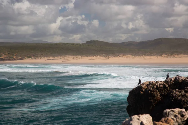 Bilinmeyen balıkçılar engebeli ve aşınmış yüksek kayalıklardan Atlas Okyanusu 'na bakan bir olta kamışlarıyla avlanırlar..