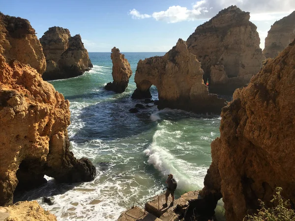 Kayaların fotoğraflarını çeken bir adam.