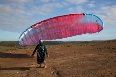 Gökyüzünde denizin üstünde uçan paraglider