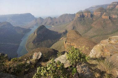 Nehirle aşındırılmış dağ manzarası vadi tabanını keserek bir kanyon oluşturuyor.