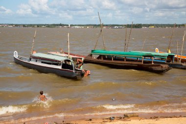 İnsanlar ve balıkçı tekneleri gün ışığında sahilde