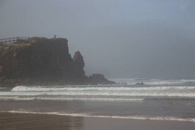 Bulutlu bir gökyüzü ile güzel bir kumsal görüntüsü.