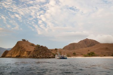 Dağlık alanda insanların gölde hareket ettiği bir tekne.