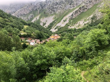 Vadideki yüksek dağ zirveleri arasındaki çiftçi köyü.