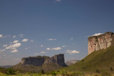 Güneşin yemyeşil olduğu kayalık manzaralı güzel bir manzara.