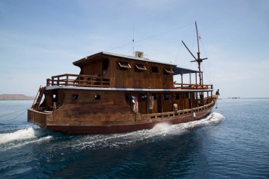 Dağlık alanda insanların gölde hareket ettiği bir tekne.