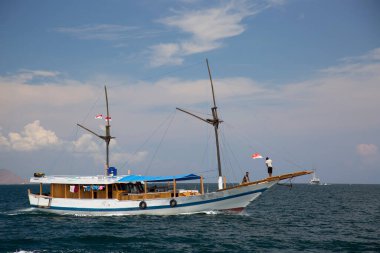 Dağlık alanda insanların gölde hareket ettiği bir tekne.