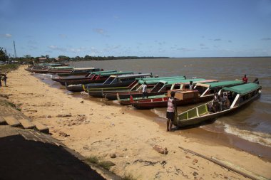 İnsanlar ve balıkçı tekneleri gün ışığında sahilde