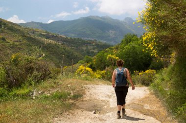 Dağlık alanda kadın yürüyüşçünün arka görüntüsü