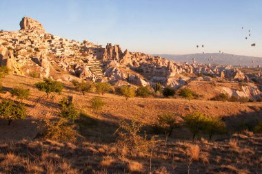 Turistlerle dolu sıcak hava balonları ulusal parkın üzerindeki volkanik bir arazide bunaltıcı manzaranın keyfini çıkarıyor.