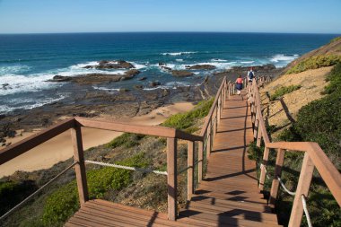 Merdivenlerden deniz kıyısına inen çift.