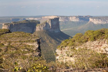 Güneşin yemyeşil olduğu kayalık manzaralı güzel bir manzara.