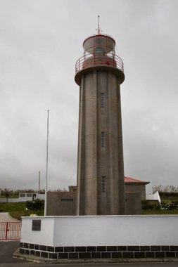 Deniz kıyısındaki deniz feneri bulutlu bir günde