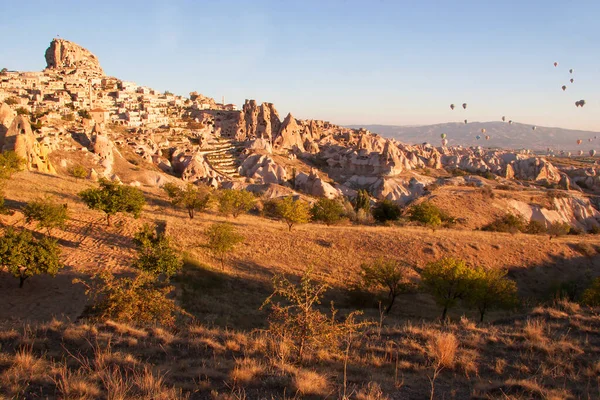Turistlerle dolu sıcak hava balonları ulusal parkın üzerindeki volkanik bir arazide bunaltıcı manzaranın keyfini çıkarıyor.