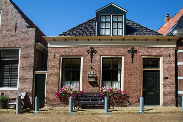 Banklar ve çiçeklerle eski bina cephesinin ön görüntüsü