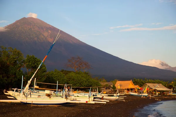 Sahilde demirlemiş kayıklar ve arka planda dağlar.