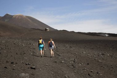 Volkanik tepelerde yürüyen iki kadın manzara, seyahat çekimi