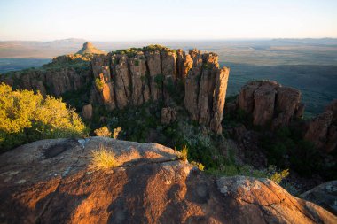 Gün batımında panoramik dağ manzarasında aşınmış kayalar önlükle kaplanır.