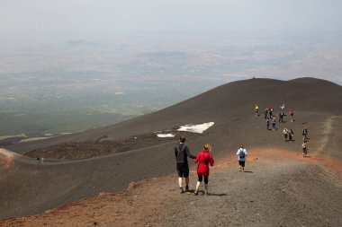 Bir grup turist güzel bir dağ manzarasında yürüyor.