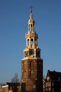 Tarihsel Montelbaan Kulesi gün batımında Amsterdam 'ın kanal kemerinde