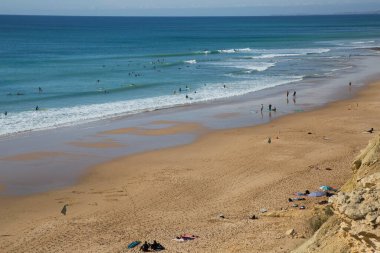 İnsanlar Atlantik Okyanusu kıyısında plajın tadını çıkarıyorlar.