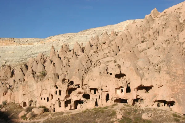 Mağara evleri ve kiliselerden oluşan antik şehir manzarası volkanik kayalara oyulmuş kapılar ve pencereler ve birçok farklı iç odalarla, bazıları çöktü.